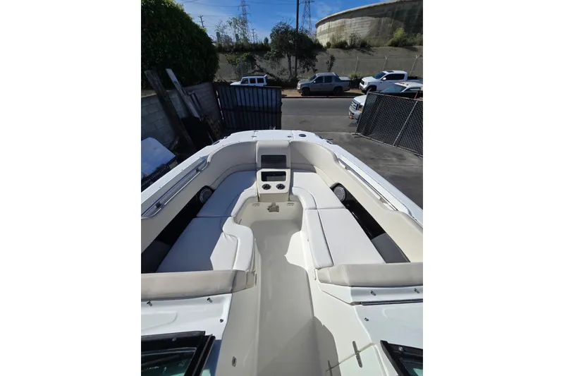 Slide: The Image of 2014 Boston Whaler 270 Vantage boat interior with seating and console, parked outdoors. - 57