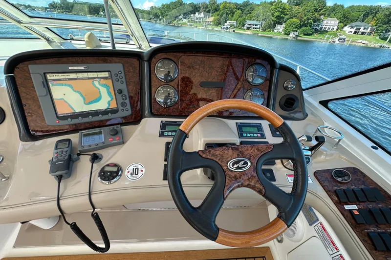 Slide: The Image of 2006 Sea Ray 52 Sundancer helm with navigation system and wood-accented steering wheel. - 12