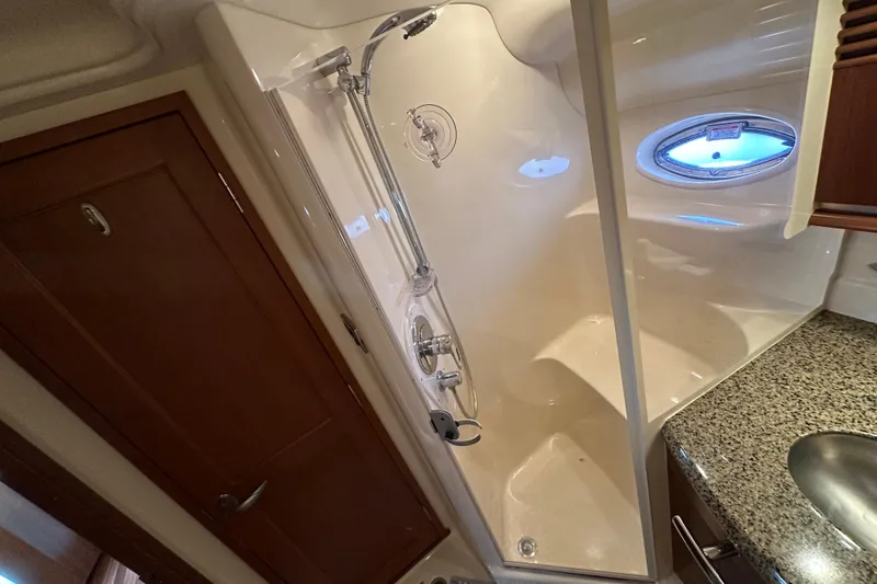 Slide: The Image of Shower area in 2006 Sea Ray 52 Sundancer yacht with granite countertop and porthole window. - 29