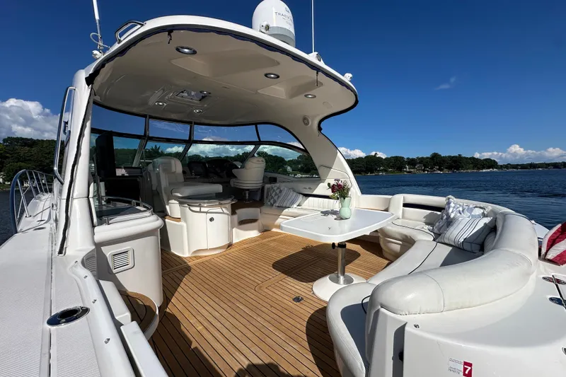Slide: The Image of 2006 Sea Ray 52 Sundancer yacht with spacious deck, elegant seating, and scenic water view. - 3