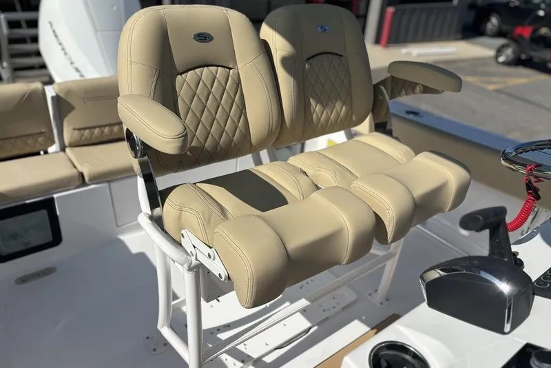 Slide: The Image of Luxurious seating on 2026 Sportsman Heritage 231 boat, featuring beige leather upholstery and armrests. - 13