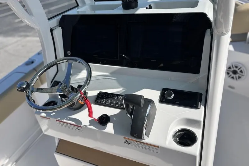 Slide: The Image of 2026 Sportsman Heritage 231 boat console with steering wheel and controls. - 14