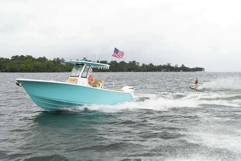 Slide: The Image of 2026 Sportsman Heritage 231 boat towing a water skier on a lake. - 28