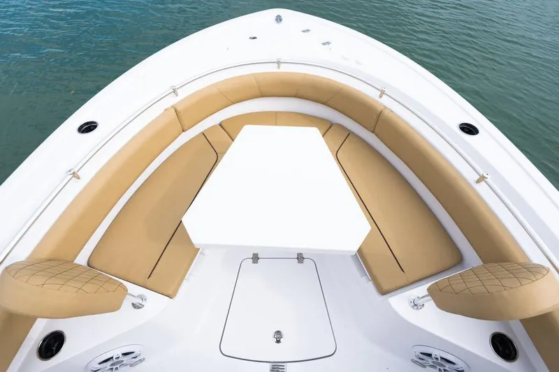 Slide: The Image of 2026 Sportsman Heritage 231 boat interior with tan seating and white table on water. - 42