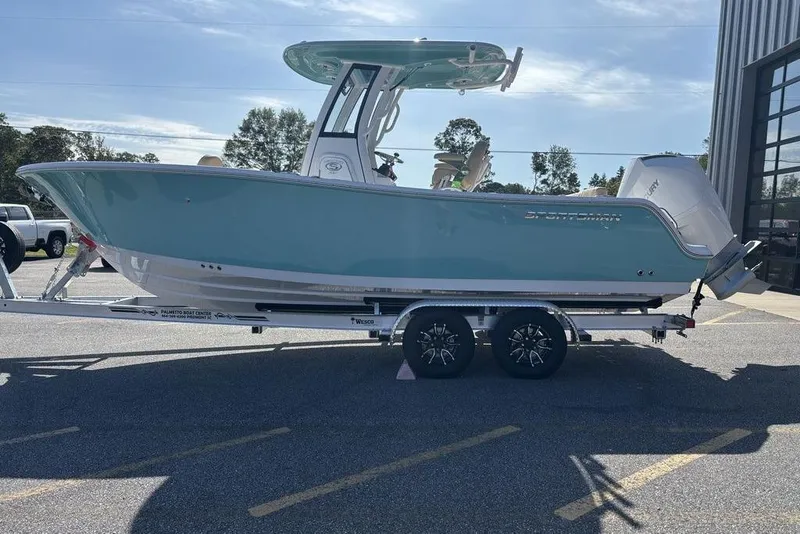 Slide: The Image of 2026 Sportsman Heritage 231 boat on trailer, parked outdoors near a building. - 7
