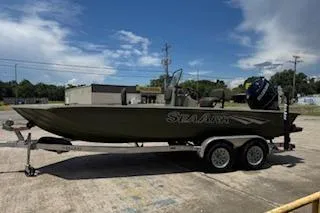 Slide: The Image of 2023 SeaArk 2072 VFX Elite CC boat on trailer, parked outdoors under blue sky. - 2