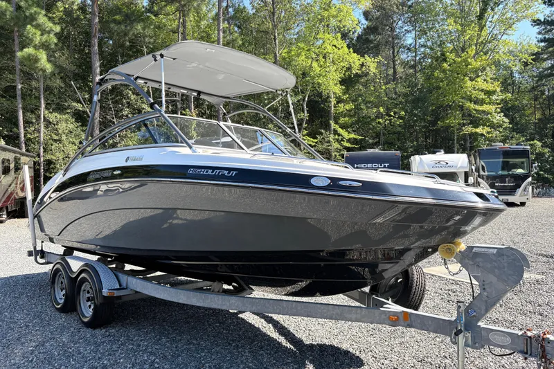 The Image of 2013 Yamaha Boats AR240 HO on trailer, parked outdoors with trees in background. - 1