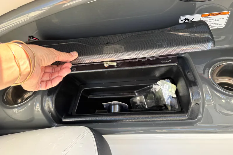 Slide: The Image of Hand opening storage compartment on 2013 Yamaha AR240 HO boat dashboard. - 17