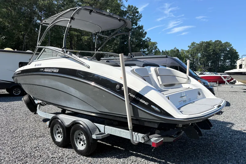 Slide: The Image of 2013 Yamaha Boats AR240 HO on trailer, parked outdoors, with canopy and twin engines. - 3