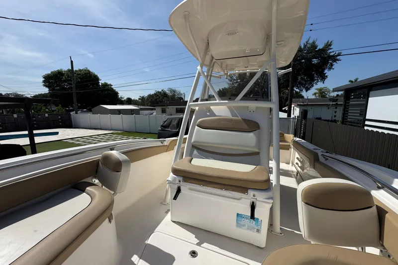 Slide: The Image of 2020 Pioneer 222 Islander boat interior with seating and console, in a residential backyard setting. - 10