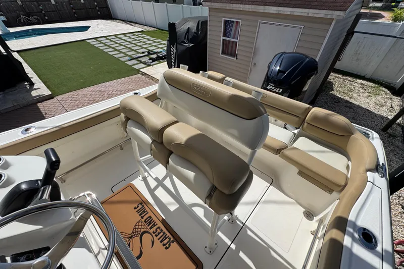 Slide: The Image of 2020 Pioneer 222 Islander boat interior with tan seating and steering wheel. - 14