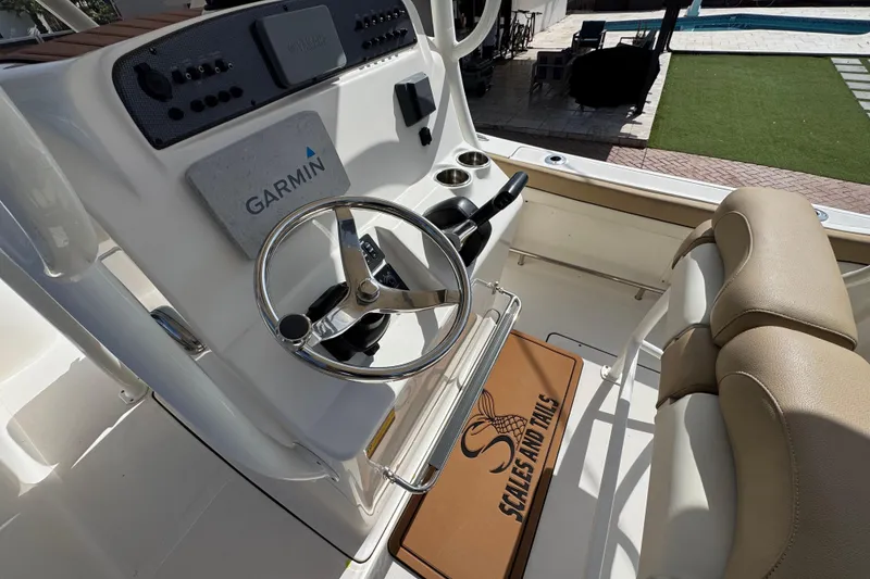 Slide: The Image of 2020 Pioneer 222 Islander boat helm with Garmin system and beige seating. - 17