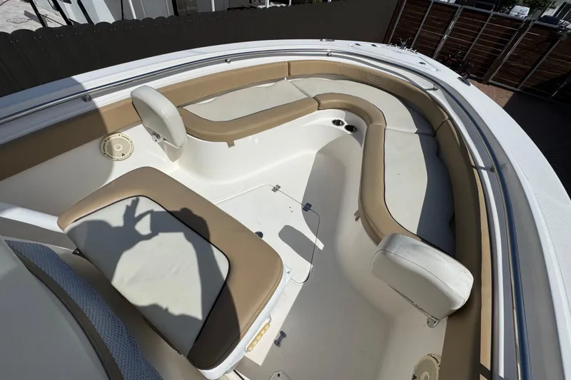 Slide: The Image of 2020 Pioneer 222 Islander boat interior with tan seating and white deck. - 20