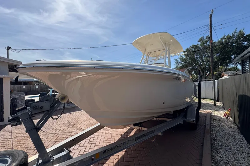 Slide: The Image of 2020 Pioneer 222 Islander boat on trailer, parked in driveway under clear sky. - 4