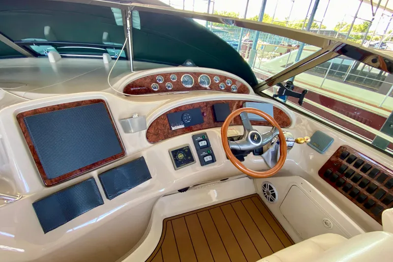 Slide: The Image of 1999 Sea Ray 460 Sundancer helm with wood accents and modern controls. - 19
