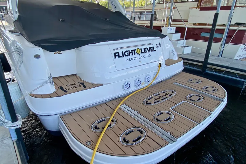 Slide: The Image of 1999 Sea Ray 460 Sundancer yacht docked, featuring teak swim platform and covered deck. - 2