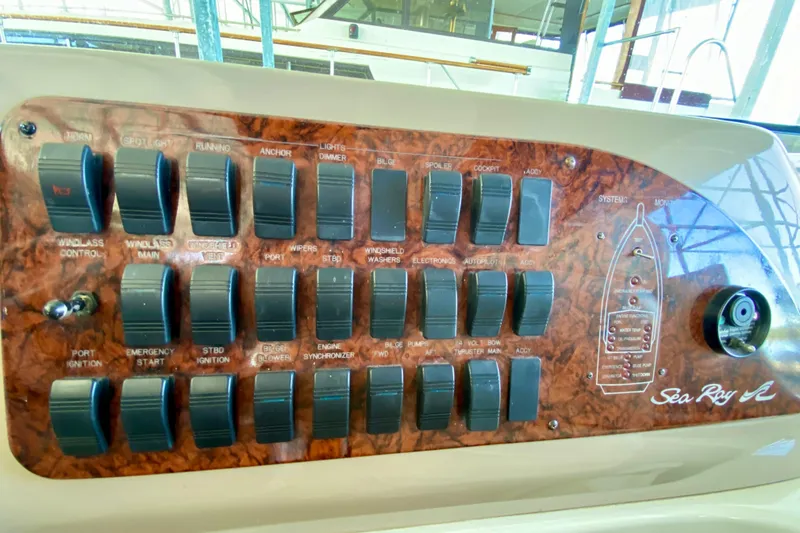 Slide: The Image of Control panel of a 1999 Sea Ray 460 Sundancer boat with various switches and labels. - 23