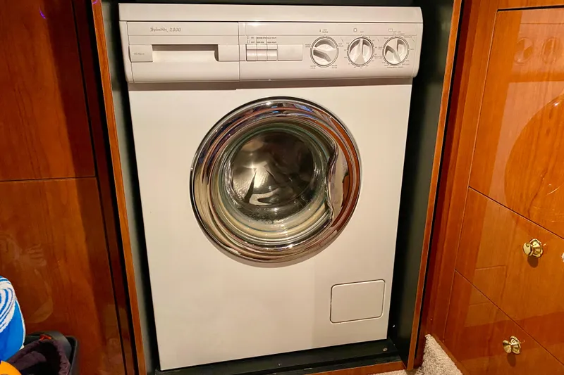 Slide: The Image of Washing machine inside 1999 Sea Ray 460 Sundancer yacht, surrounded by wooden cabinetry. - 34
