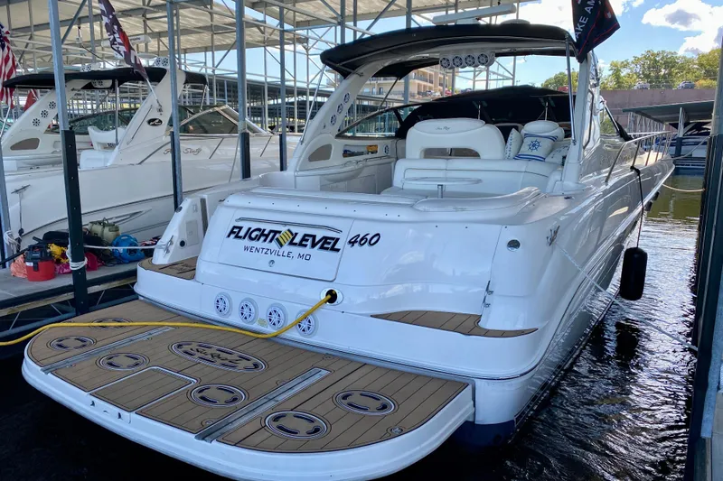 Slide: The Image of 1999 Sea Ray 460 Sundancer yacht docked, featuring spacious deck and elegant design. - 4