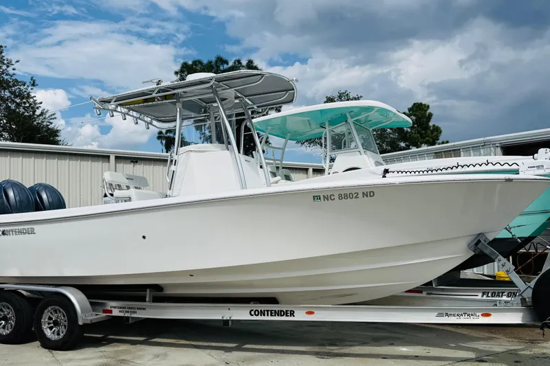 The Image of 2024 Contender 25 Open boat on trailer, parked outdoors under cloudy sky. - 1