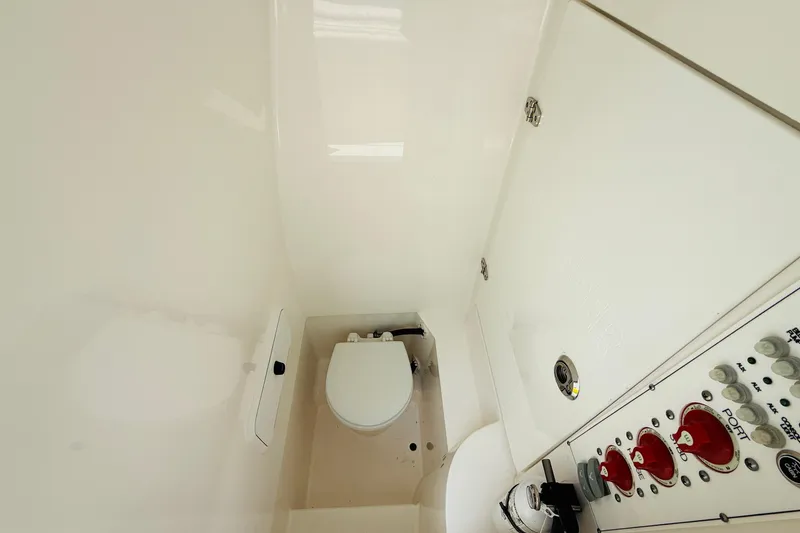 Slide: The Image of 2024 Contender 25 Open boat interior with toilet and control panel. - 3