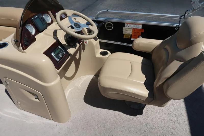 Slide: The Image of 2013 Berkshire 231RFCSTS13 boat interior with beige captain's chair and steering console. - 9