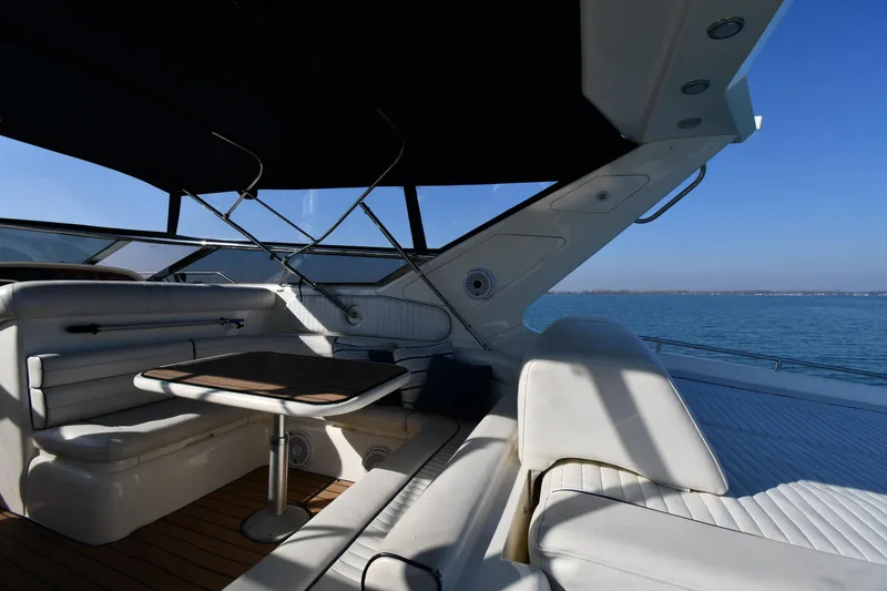 Slide: The Image of Sunseeker 55 CAMARGUE 1996 yacht interior with seating and table, overlooking calm blue waters. - 24
