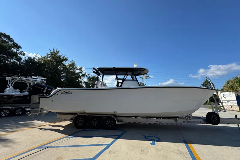 Slide: The Image of 2023 Invincible 35 Catamaran on trailer under clear blue sky. - 10