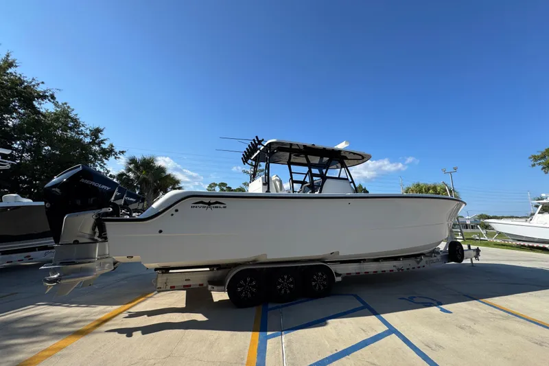 Slide: The Image of 2023 Invincible 35 Catamaran on trailer, featuring dual Mercury engines, parked outdoors. - 11