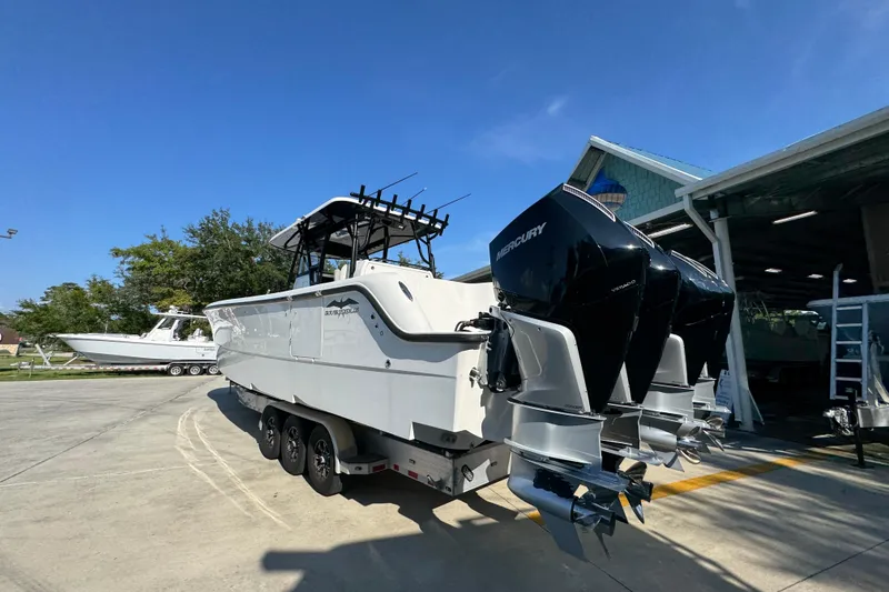 Slide: The Image of 2023 Invincible 35 Catamaran with Mercury engines, parked outdoors under clear blue sky. - 17