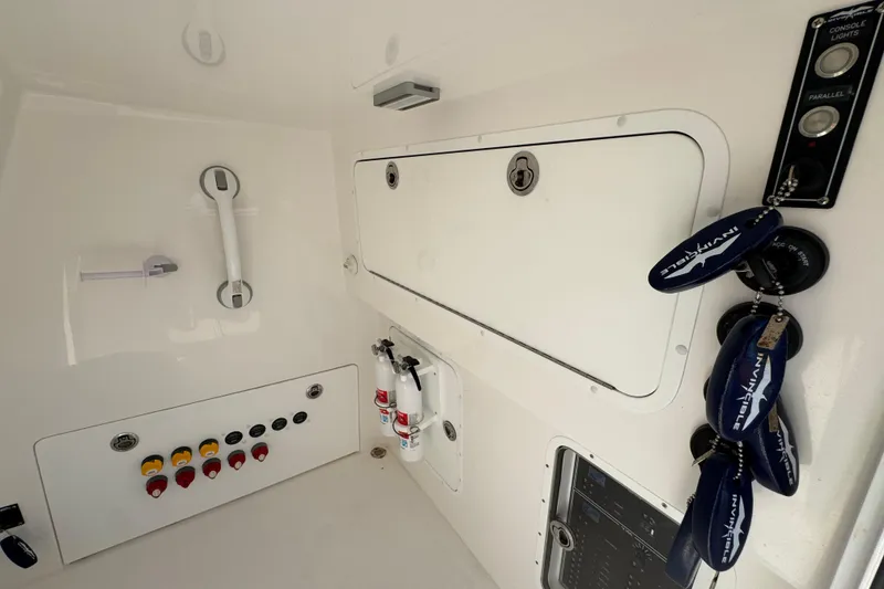 Slide: The Image of 2023 Invincible 35 Catamaran interior with control panel, keys, and safety equipment. - 26