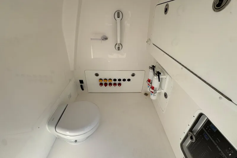 Slide: The Image of Interior of 2023 Invincible 35 Catamaran featuring a compact marine toilet and control panel. - 27