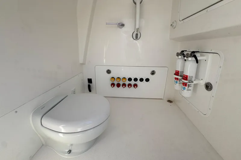 Slide: The Image of 2023 Invincible 35 Catamaran interior with toilet, control panel, and fire extinguishers. - 28