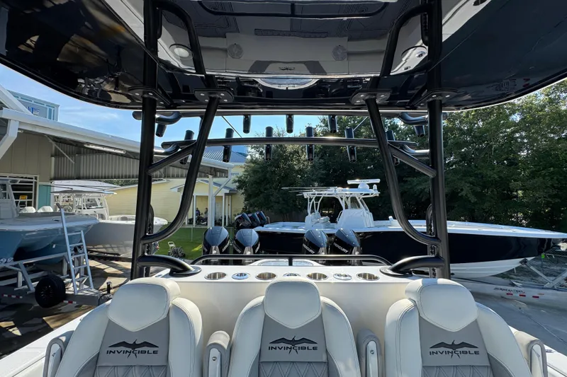 Slide: The Image of 2023 Invincible 35 Catamaran interior with seating and rod holders, docked at a marina. - 31