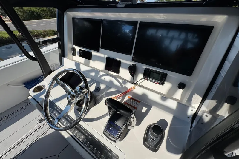 Slide: The Image of 2023 Invincible 35 Catamaran helm with modern controls and multiple display screens. - 35