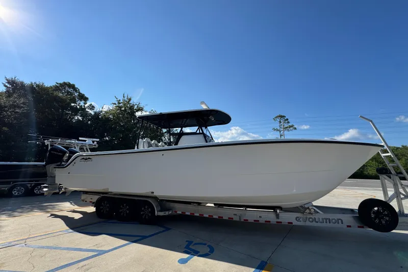 Slide: The Image of 2023 Invincible 35 Catamaran on trailer under clear blue sky. - 9
