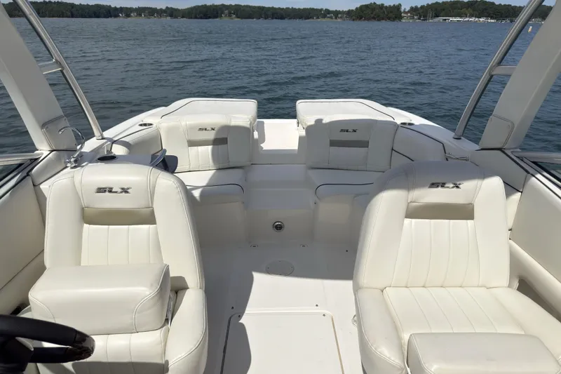 Slide: The Image of 2007 Sea Ray 250 SLX boat interior with white leather seats on a lake. - 11
