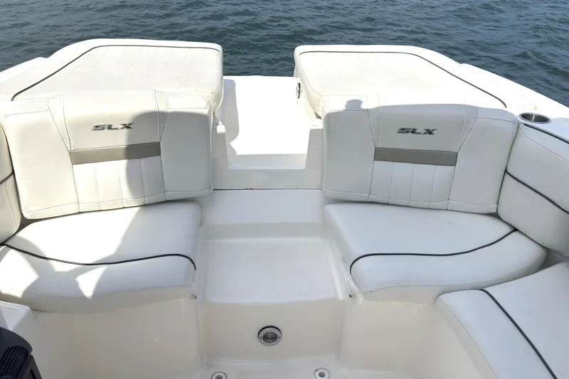 Slide: The Image of 2007 Sea Ray 250 SLX boat with white leather seating, on calm water. - 13