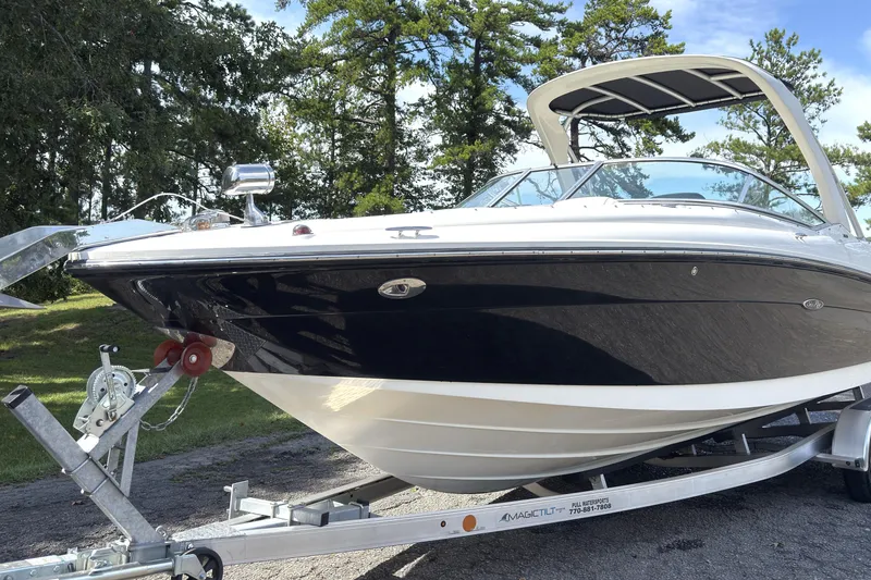 Slide: The Image of 2007 Sea Ray 250 SLX boat on trailer, parked outdoors with trees in background. - 17
