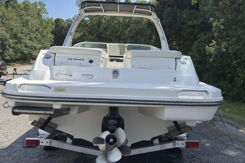 Slide: The Image of 2007 Sea Ray 250 SLX boat rear view, on trailer, surrounded by trees. - 19