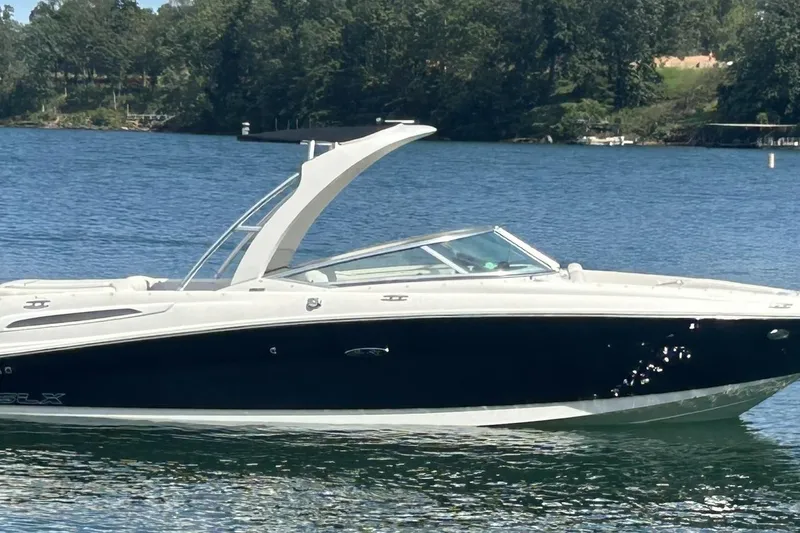 Slide: The Image of 2007 Sea Ray 250 SLX boat on a serene lake with lush green shoreline. - 2