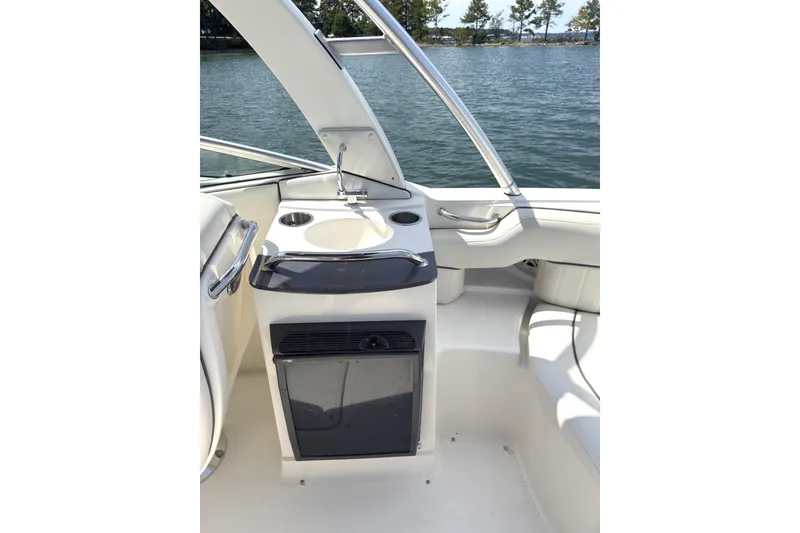 Slide: The Image of 2007 Sea Ray 250 SLX boat interior with sink and seating, overlooking a serene lake. - 5