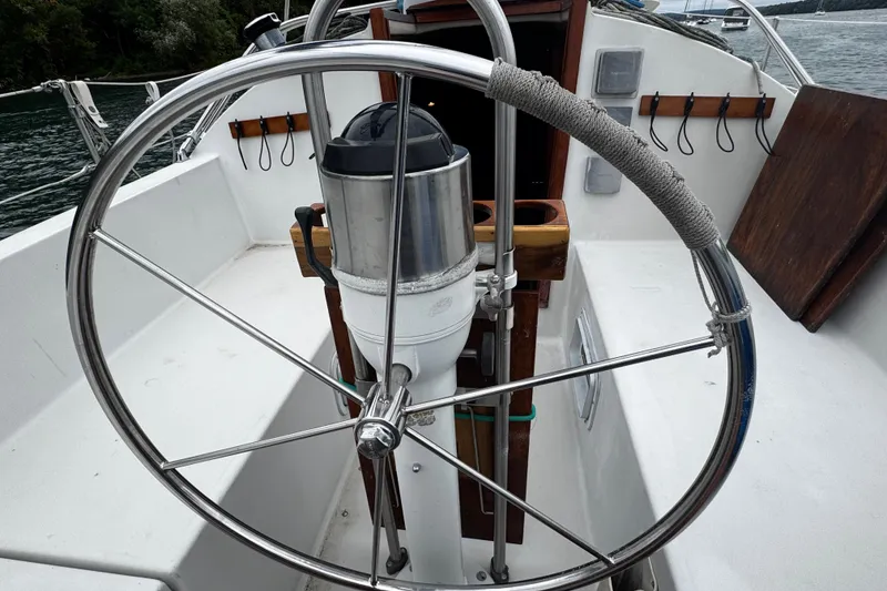 Slide: The Image of 1984 Nonsuch 26 Classic sailboat cockpit with stainless steel wheel and nautical equipment. - 11