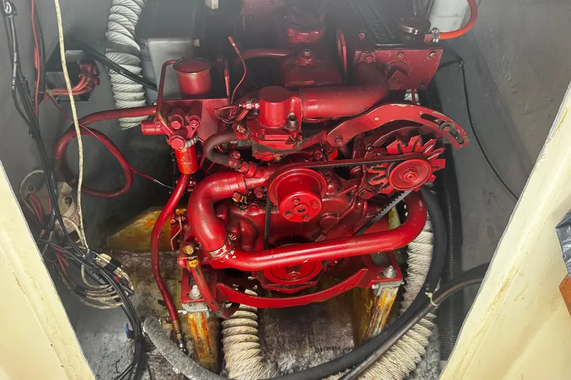 Slide: The Image of Red engine inside a 1984 Nonsuch 26 Classic sailboat, showcasing mechanical components and wiring. - 21