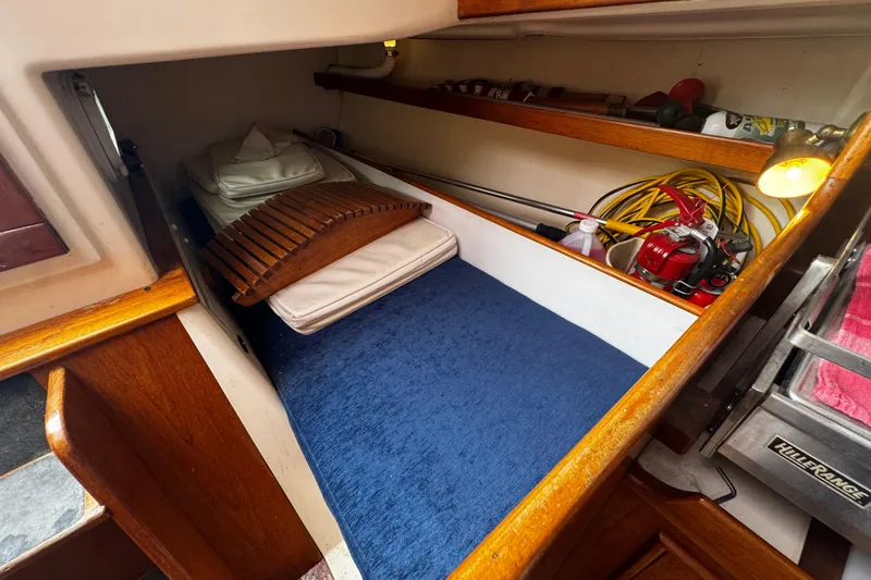 Slide: The Image of Cozy cabin interior of 1984 Nonsuch 26 Classic sailboat with blue bedding and wooden accents. - 23