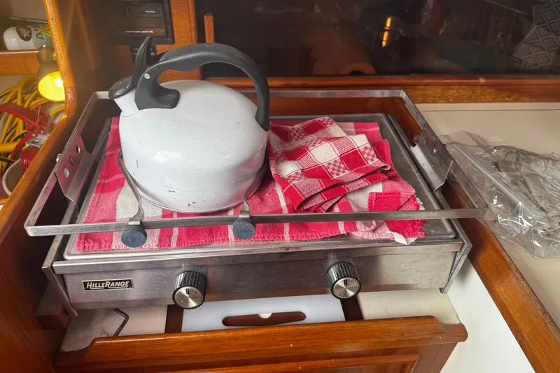 Slide: The Image of Kettle and red checkered cloth on stove inside 1984 Nonsuch 26 Classic boat. - 24