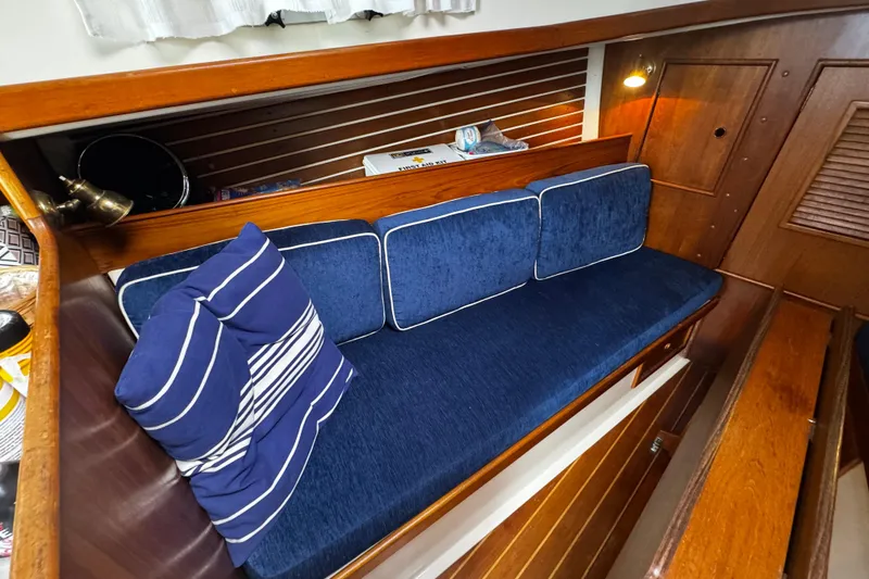 Slide: The Image of 1984 Nonsuch 26 Classic interior with blue cushioned seating and wooden paneling. - 30