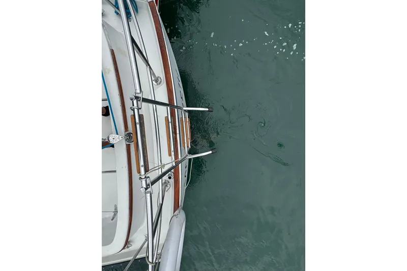 Slide: The Image of Top view of a 1984 Nonsuch 26 Classic sailboat's deck and railing over water. - 35