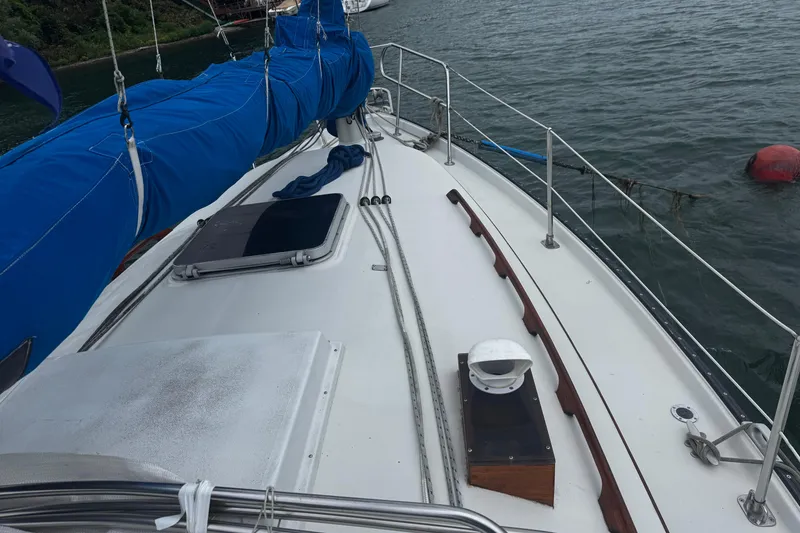 Slide: The Image of 1984 Nonsuch 26 Classic sailboat deck with blue sail cover on calm water. - 36