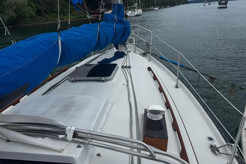 Slide: The Image of 1984 Nonsuch 26 Classic sailboat deck with blue sail cover on calm water. - 5
